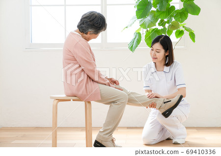 Caregiver assisting in rehabilitation Caregiver assisting in rehabilitation 69410336