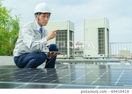 Male worker inspecting solar panels Male worker inspecting solar panels 69410419