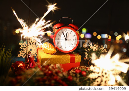 Hands on red alarm clock show time of new year's celebration 69414009