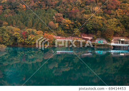Gradation of autumn leaves and reflection on the water surface 69414453