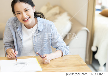 A young woman sketching her hobby at home 69414645