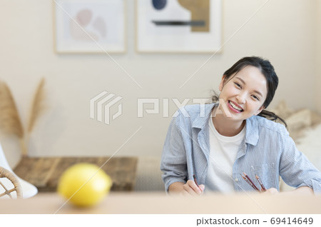 一個年輕的女人，她在家裡素描愛好 69414649