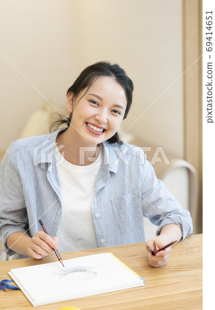 一個年輕的女人，她在家裡素描愛好 69414651