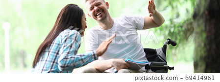 Male disabled man with girlfriend smiling on park walk portrait Male disabled man with girlfriend smiling on park walk portrait 69414961