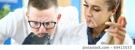 Two chemists on meet against chemistry lab background. 69415033