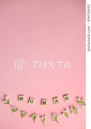 Top view woman spelled in wooden blocks on pink background. Love, 8 march background. Gift, greeting, compliment concept. Copy space. place for text. 69416642