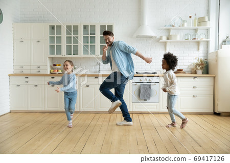 Overjoyed international family dancing, enjoying weekend time. Overjoyed international family dancing, enjoying weekend time. 69417126