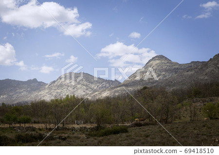 Landscape of a valley at the foot of a mountain 69418510