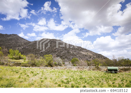 Landscape of a valley at the foot of a mountain 69418512