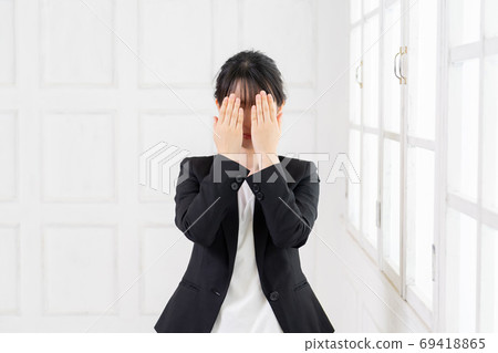 Young business woman hiding her face Young business woman hiding her face 69418865