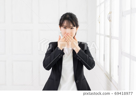 Young business woman who hides her mouth 69418977