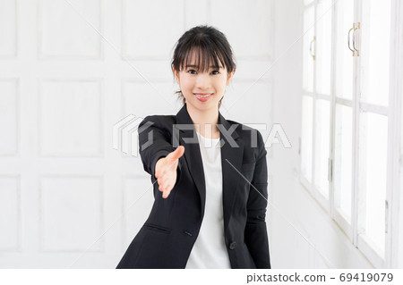 提供她的有握手的一個年輕女商人手 提供她的有握手的一個年輕女商人手 69419079