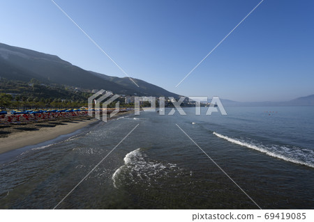 View of the beach on seaside city of Vlore. On the horizon is the Peninsula of Karaburun. 69419085