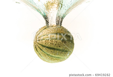 Cantaloupe melon splashing into water isolated on white background Cantaloupe melon splashing into water isolated on white background 69419282