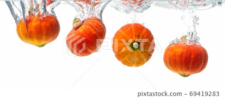 Four orange pumpkins splashing into crystal clear water. Product isolated on white background. Four orange pumpkins splashing into crystal clear water. Product isolated on white background. 69419283