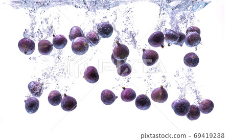Fresh figs falling into the water isolated on white background. Food photography. Fresh figs falling into the water isolated on white background. Food photography. 69419288