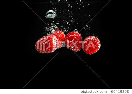 Raspberries splashing into clear water isolated on black background. Raspberries splashing into clear water isolated on black background. 69419298