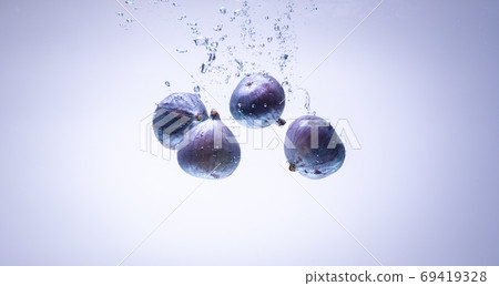 Fresh figs falling into the water isolated on white background. Food photography. Fresh figs falling into the water isolated on white background. Food photography. 69419328