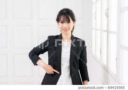 一個年輕的商業女人把她的手放在她的肚子上 一個年輕的商業女人把她的手放在她的肚子上 69419365