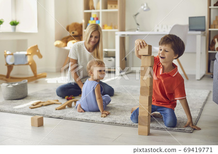 Mother playing with happy children on floor at home 69419771