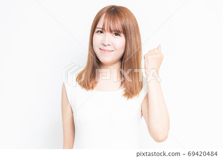 A young woman who plays guts pose 69420484