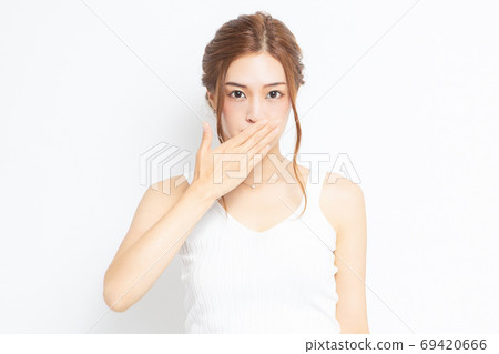 Young woman putting hands on mouth Young woman putting hands on mouth 69420666