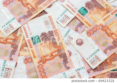 Five-thousandth Russian bills lie chaotically on the table Five-thousandth Russian bills lie chaotically on the table 69421528