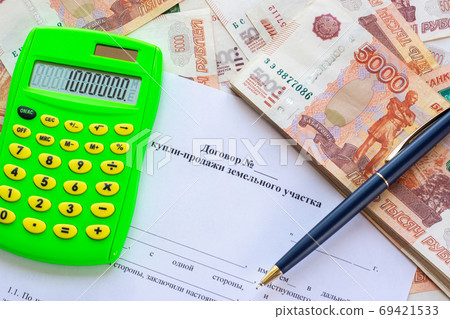 The contract for the sale of the land plot contains a calculator, a wad of money and a pen 69421533