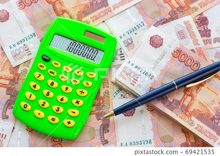 The number 1,000,000 is written on the calculator, the calculator and the ballpoint pen lie on a pile of money 69421535