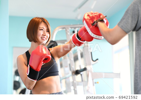 年輕女子在健身房裡打手套 年輕女子在健身房裡打手套 69421592
