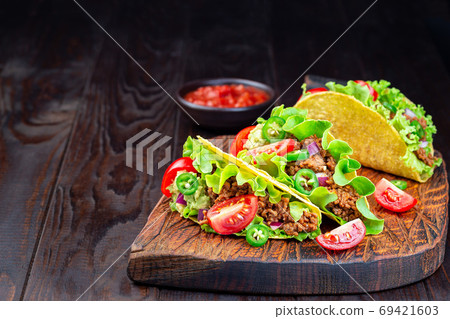 Taco with ground beef meat, mashed avocado, tomato 69421603