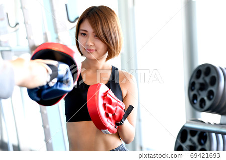 Young woman with a mitt in the gym 69421693