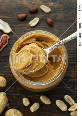 peanut paste in an open jar and peanuts in the peel peanut paste in an open jar and peanuts in the peel 69421760