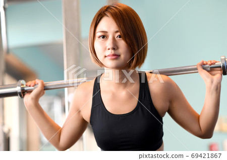 Young woman squatting in the gym 69421867