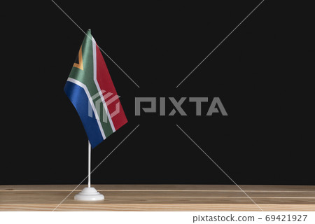 National flag of South Africa on table, black background. Flag pole. Copy space 69421927