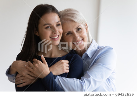 Happy older mom and adult millennial daughter hugging 69422659