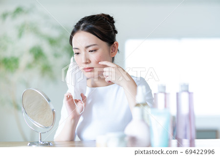 Young woman worries about rough skin due to mask 69422996