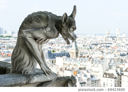 Gargoyle statue with city of Paris on background Gargoyle statue with city of Paris on background 69423600
