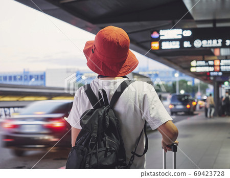 Solo traveler carry luggage walking in airport 69423728