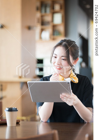 Young woman using a tablet in a cafe 69424702