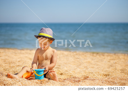 little boy playing on the sea beach little boy playing on the sea beach 69425257