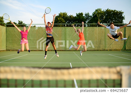 Mixed doubles tennis, players jump near the net 69425687