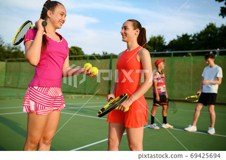 Mixed doubles tennis, happy players after game Mixed doubles tennis, happy players after game 69425694
