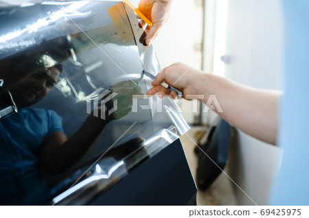 Male wrapper holds sunscreen film, car tinting Male wrapper holds sunscreen film, car tinting 69425975