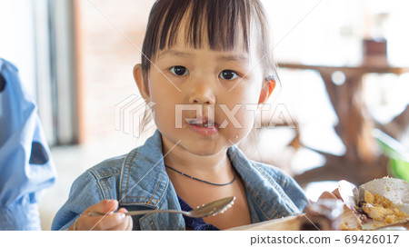 Portrait of a cute Asian girl after eating delicious chocolate cake in a restaurant with copy space for your text. Portrait of a cute Asian girl after eating delicious chocolate cake in a restaurant with copy space for your text. 69426017