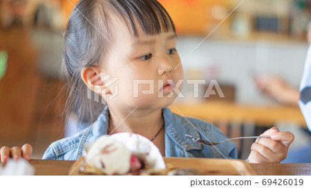 Portrait of a cute Asian girl after eating delicious chocolate cake in a restaurant with copy space for your text. Portrait of a cute Asian girl after eating delicious chocolate cake in a restaurant with copy space for your text. 69426019