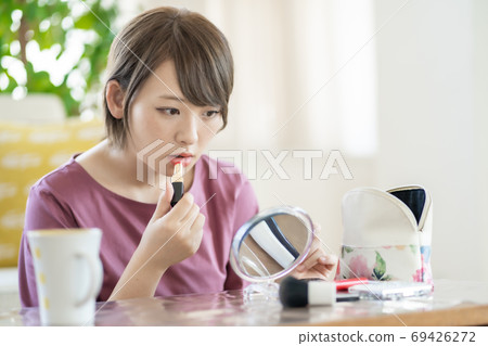 年輕女子在家裡化妝 年輕女子在家裡化妝 69426272