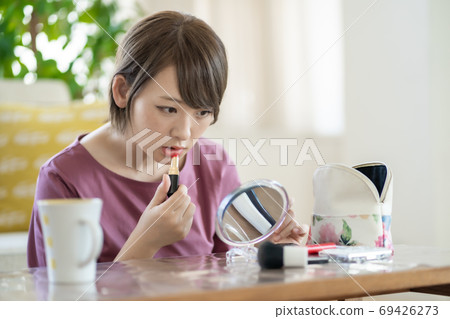 年輕女子在家裡化妝 年輕女子在家裡化妝 69426273