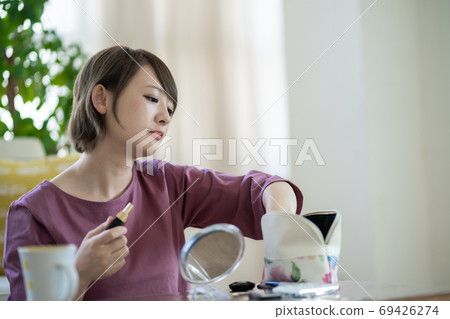 年輕女子在家裡化妝 年輕女子在家裡化妝 69426274