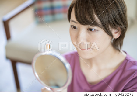 年輕女子在家裡化妝 年輕女子在家裡化妝 69426275